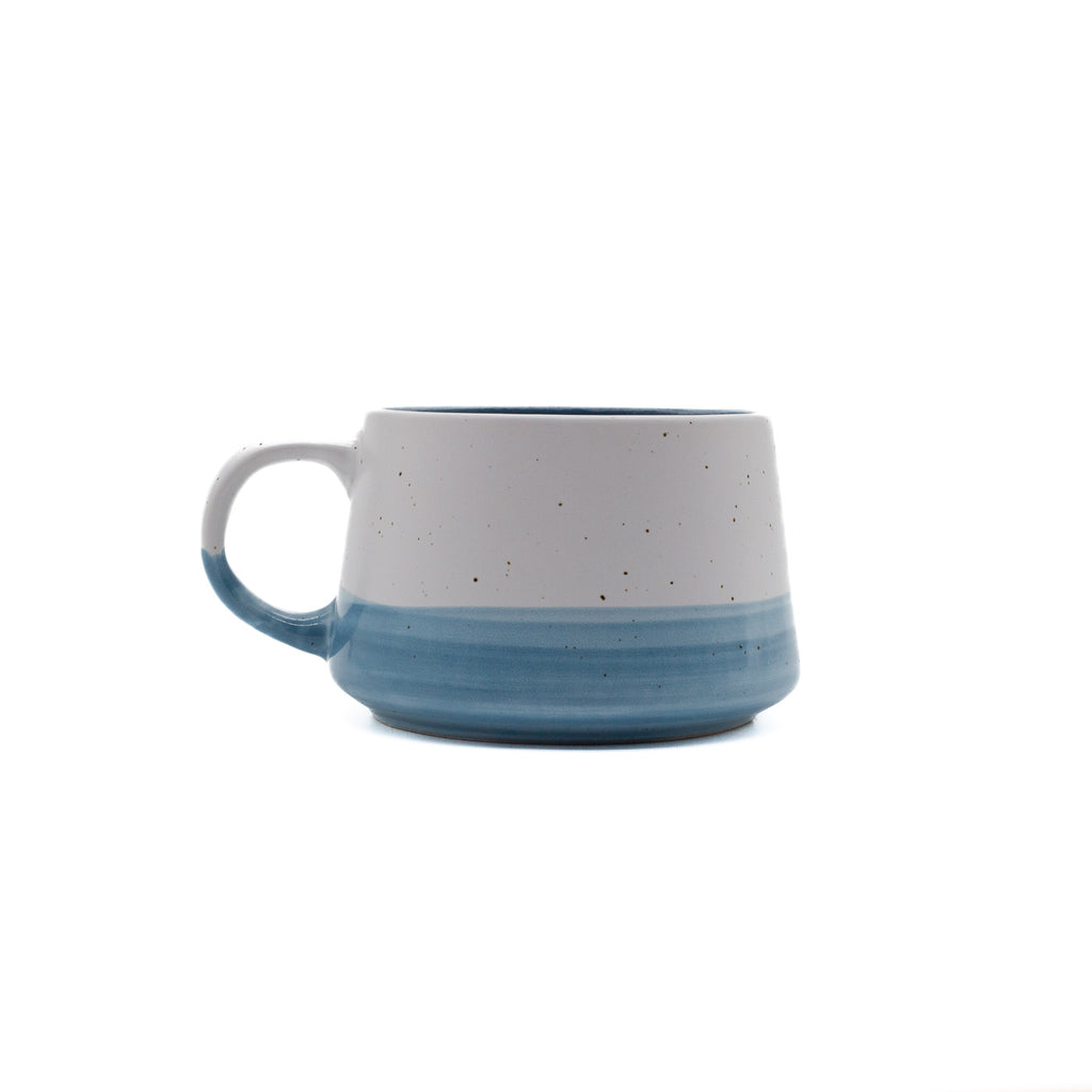 Speckled ceramic mug with blue accent on a white background