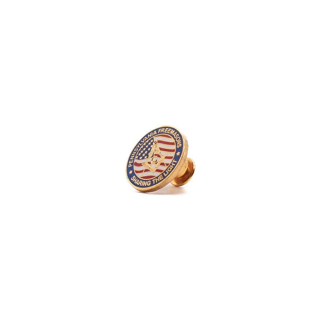 Gold-colored lapel pin with American flag and Square and Compasses design on a white background