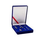 Set of mini silver Masonic tools in a blue box with a red ribbon on a white background.