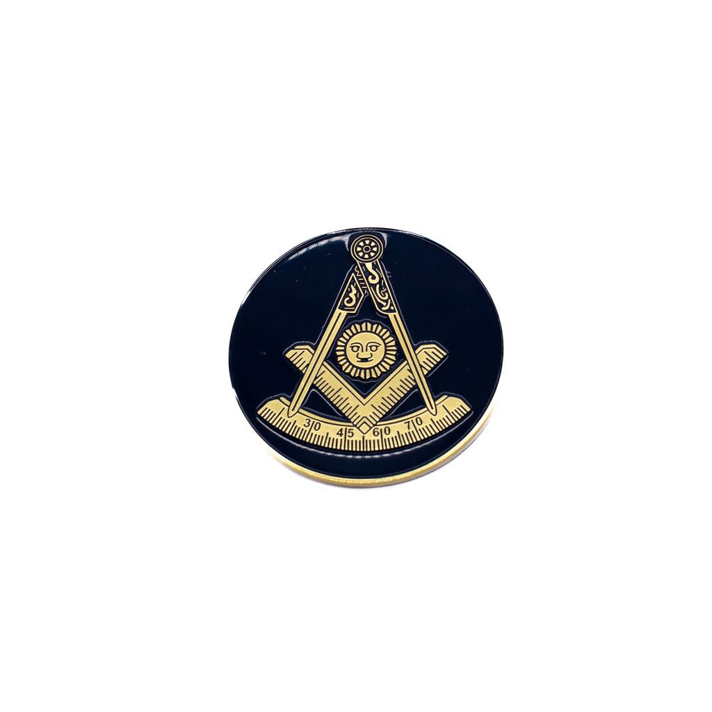 Gold-toned Square and Compasses with a sun in the center on a dark background.