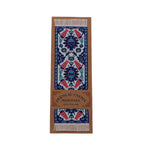 Oriental floral carpet bookmark with decorative pattern on a cardboard backing on a white background.