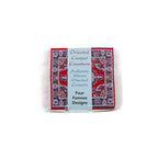 Set of red oriental carpet coasters wrapped in blue decorative packaging on a white background