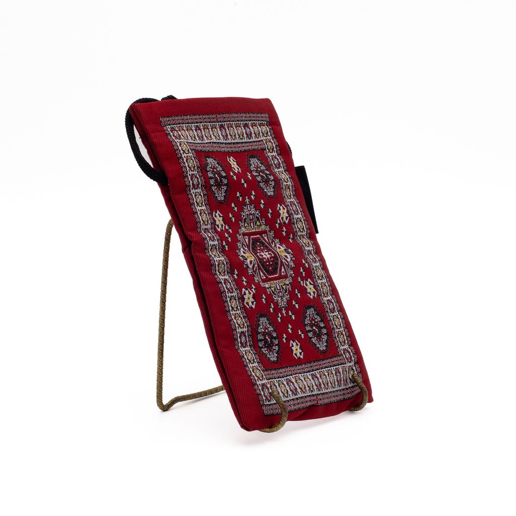 Red patterned pouch held up by a metal stand on a white background