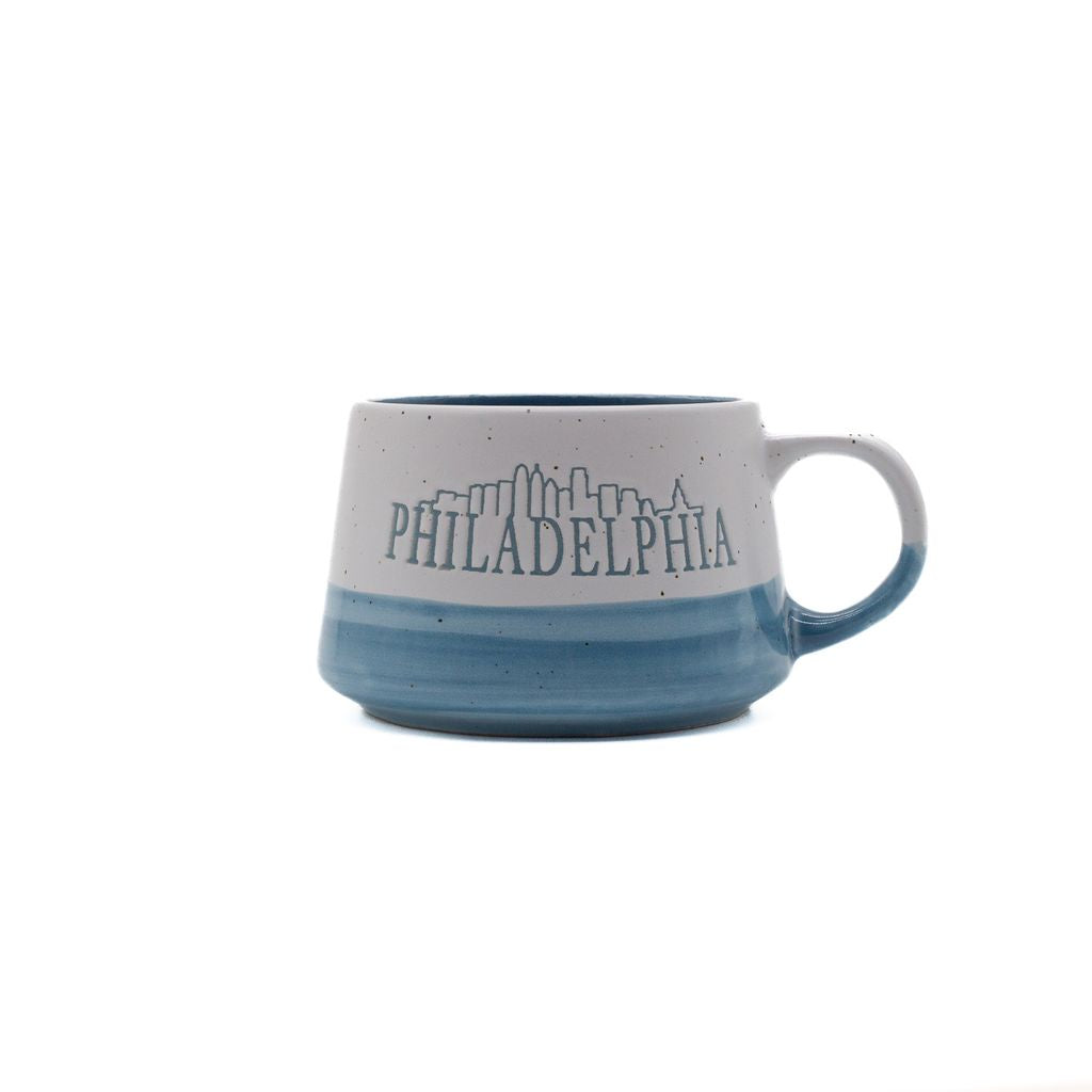 Speckled two-tone mug with blue interior, featuring the word 'Philadelphia' with an outline of the city skyline.