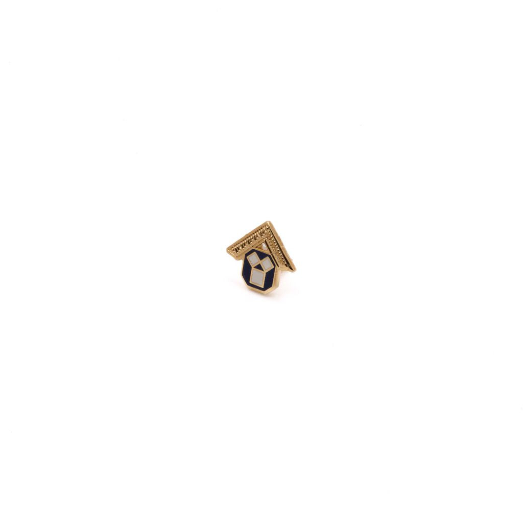 Small gold, white and black pin on a white background