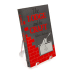 Book titled 'The Lodge and the Craft' by Rollin C. Blackmer on a stand with a white background