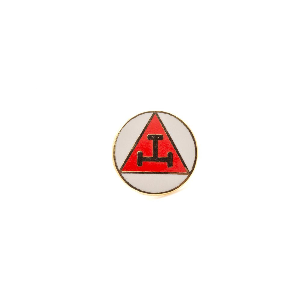 Pin with red and gold triangular design on a white background
