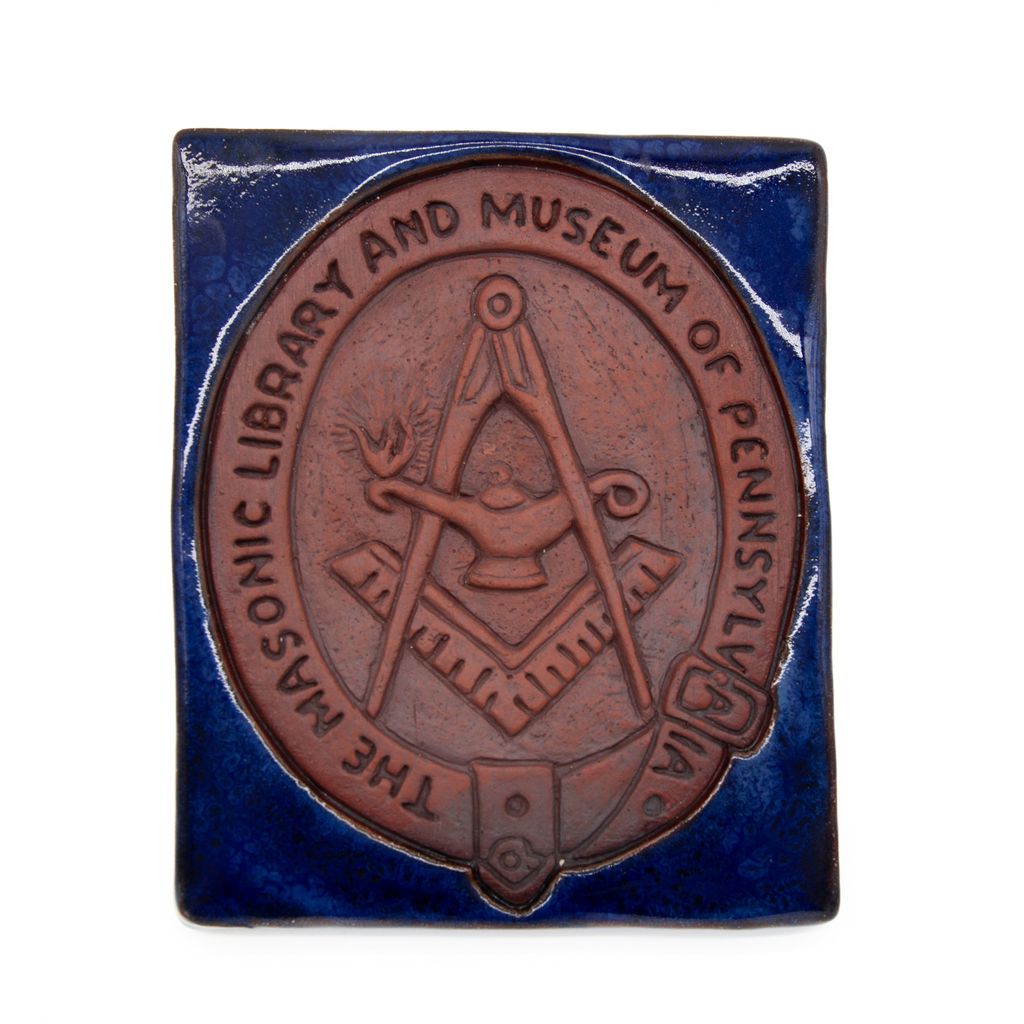 Tile with Masonic design and text on a blue background