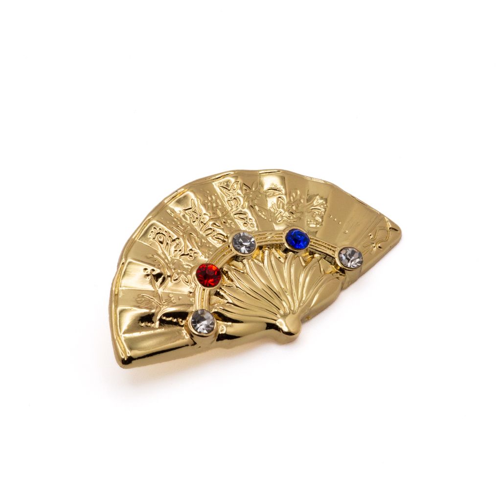 Gold fan-shaped lapel pin with embedded imitation gems on a white background