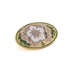 Decorative lapel pin with floral design on a white background