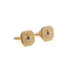 Gold cufflinks with Square and Compass design on a white background