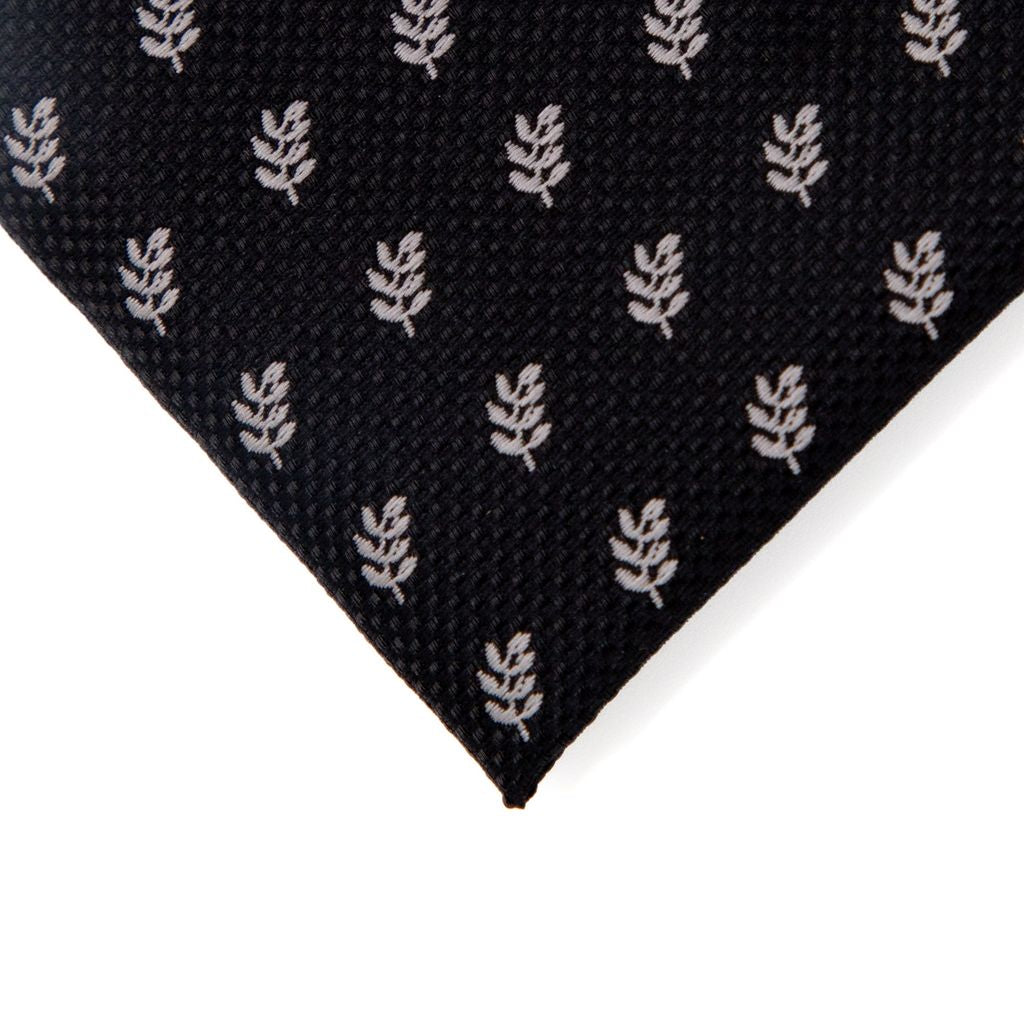 Closeup of black fabric with acacia pattern on a white background
