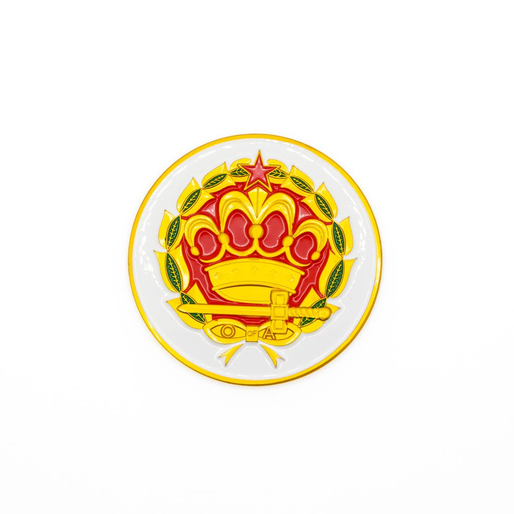 Circular emblem with a red, green and yellow crown and sword design on a white background