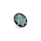 Lapel pin with silver square and compass design comprised of knives and forks on a white background