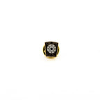 Lapel pin featuring white circle in the center with gold letters and black border.