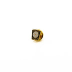 Lapel pin featuring white circle in the center with gold letters and black border.