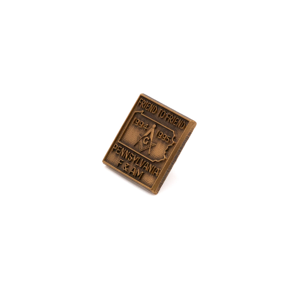 Bronze-colored metal pin with 'Friend to Friend, 1994 1995 PENNSYLVANIA F & M' text on a white background